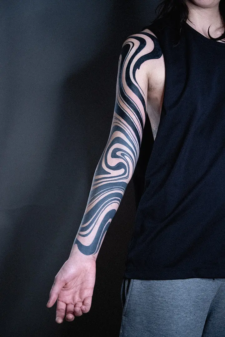 Tatuaje de manga completa con estilo suminagashi fluidos en blackwork / blackout hecha por Tikka Tattoo en Karratu Tattoo Estudio de Tatuajes.