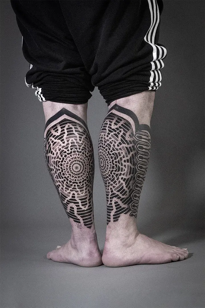 Tatuajes geométricos tipo fractal realizados en los gemelos en grises y negros. Realizado por Javi Tikka en Karratu Tattoo