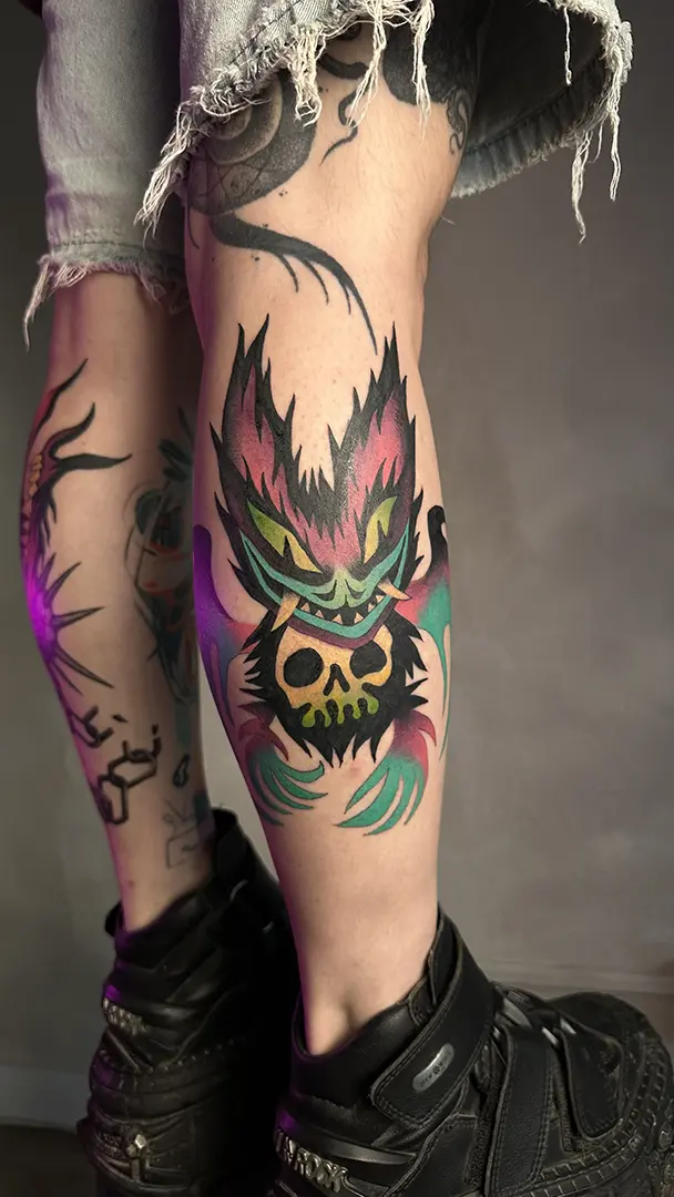 Tatuaje a color explosivo de un murciélago de estilo ilustrativo y sin líneas, en morados, granates, verdes y turquesas, realizado por Don Ander en Bilbao.