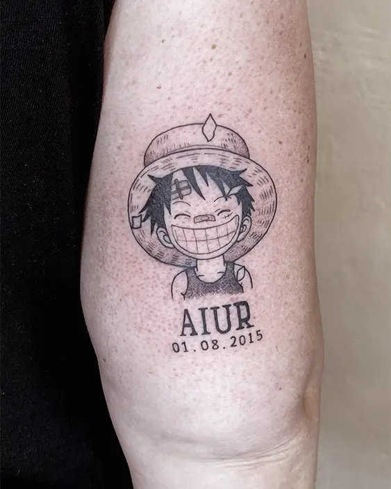Tatuaje de Luffy de niño con nombre y fecha, hecho por Don Ander De Órganos en Karratu Tattoo con la técnica de línea fina y dotwork en blanco y negro .