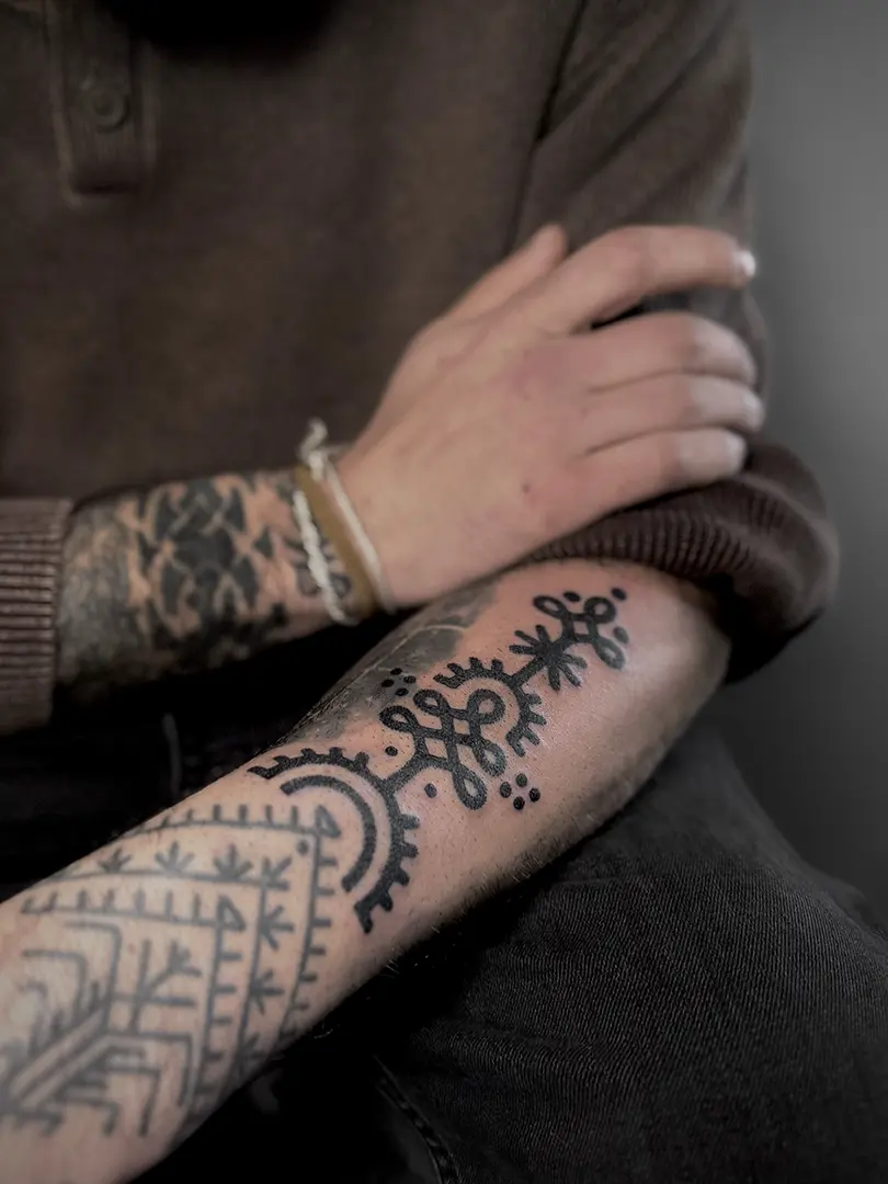 Tatuaje bold ornamental en el brazo, continuando un antiguo tatuaje de estilo bereber. El tattoo esta realizado a puntillismo por la tatuadora Julia Gris, en Karratu Tattoo