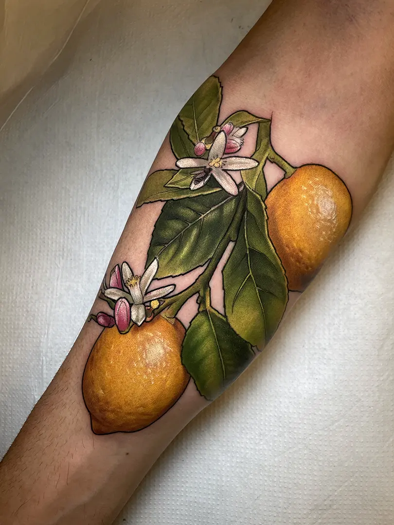Tatuaje neotradicional de un limonero con limones a color, realizado por Helena Ayala en Dele Studio Bilbao con gran detalle y realismo.